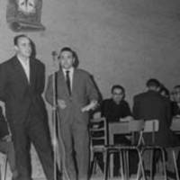 Oholtzan, xx kantuan; aldamenean zutik, Alfonso Irigoien gai-jartzailea. Atzean eserita,  Lazkao Txiki eta xx. Eskuman mahaian eserita, Euskaltzaindiako epaileak. --