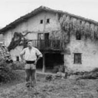 Baserritarrak: gorputz erdiz eta baserri aurrean --